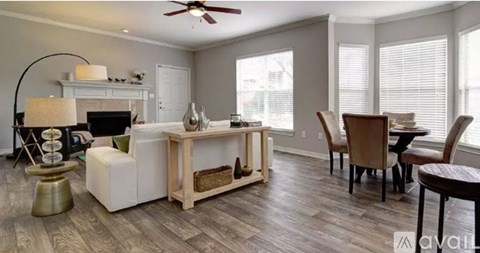 A living room with a white sofa, a wooden coffee table, and a ceiling fan.