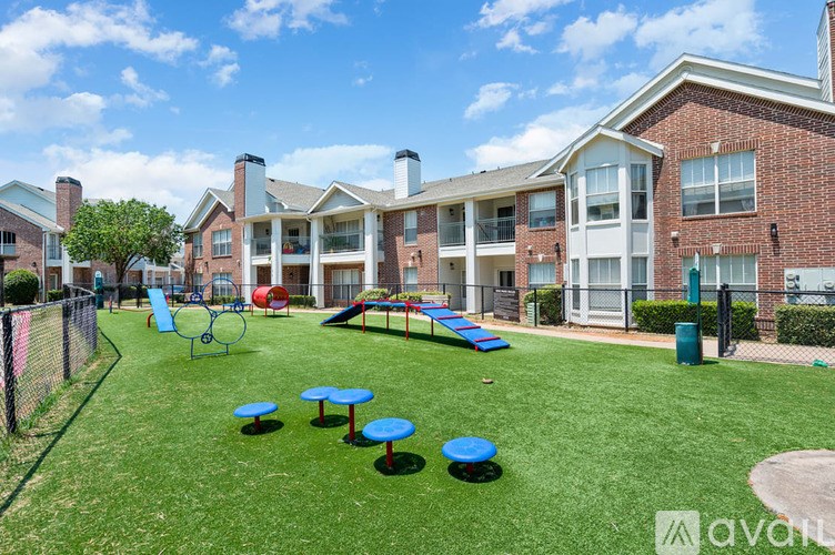 A playground area with a slide, swings, and tables in front of apartment buildings.