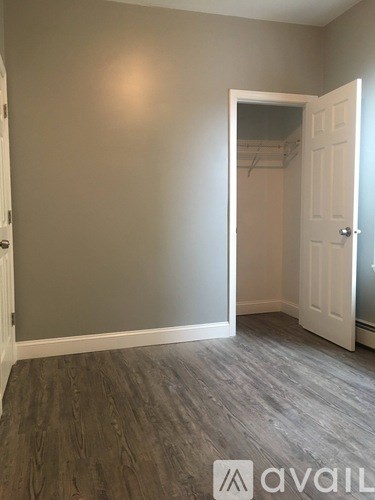 A room with a grey wall and a white door.