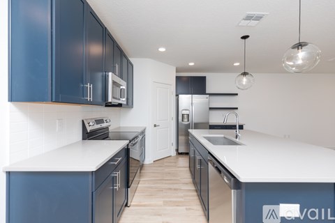 A kitchen with blue cabinets and white countertops.