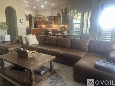 A living room with a brown leather couch and a wooden coffee table.