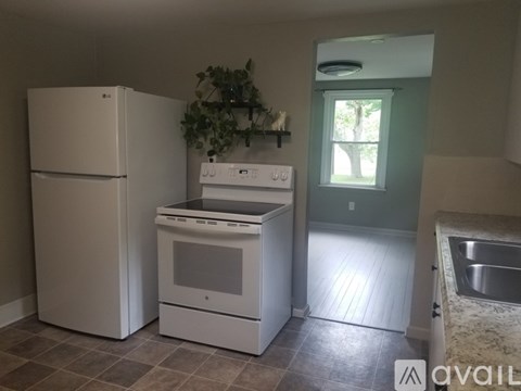 A kitchen with a white fridge, dishwasher and oven.