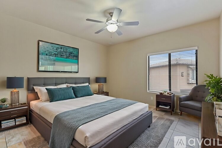 A bedroom with a bed, a chair, and a ceiling fan.