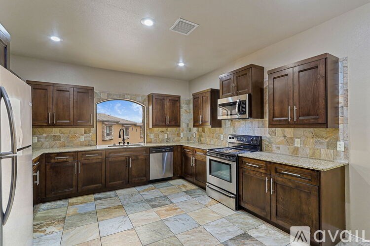 A kitchen with wooden cabinets and granite countertops.