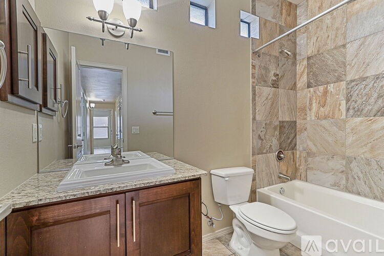 A bathroom with a marble countertop and a bathtub.