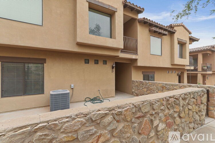 A stone wall separates the front of a house from the street.