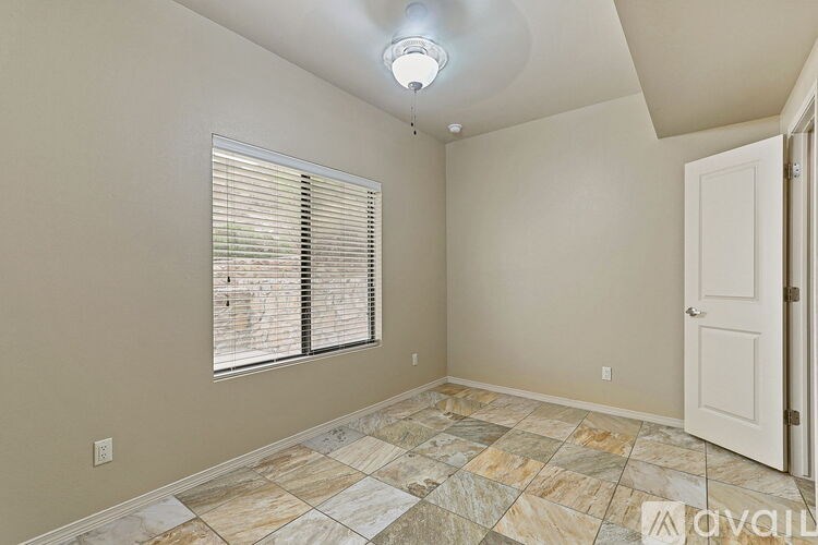 A room with a tiled floor and a window with blinds.