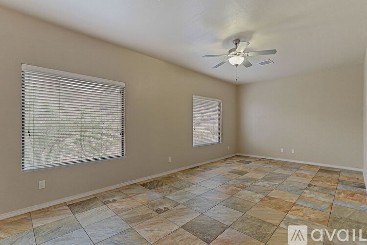 A room with a ceiling fan and tiled flooring.