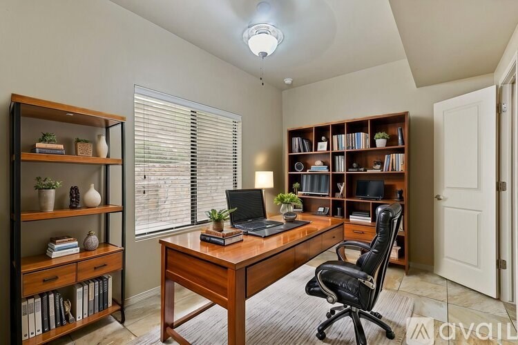A home office with a desk, chair, and bookshelves.