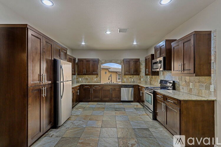 A kitchen with brown cabinets and a tiled floor.