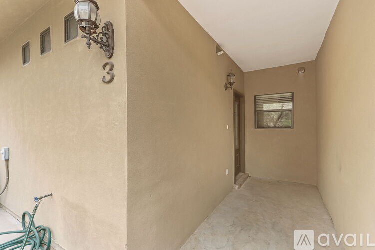 A room with a wall-mounted lamp and a window with blinds.