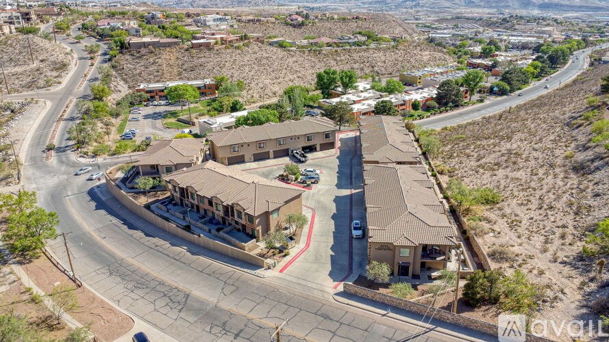 A bird's eye view of a road with a building on the side and cars parked in front.
