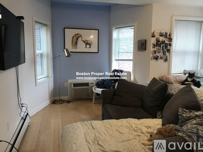 A bedroom with a bed, couch, and a painting on the wall.