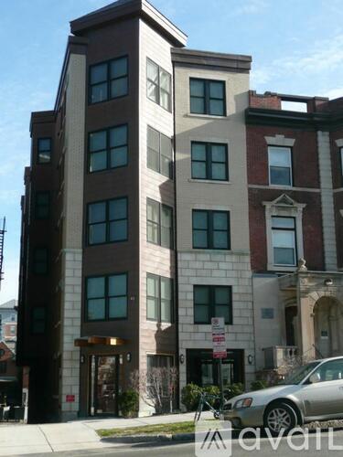 A tall building with a car parked in front of it.