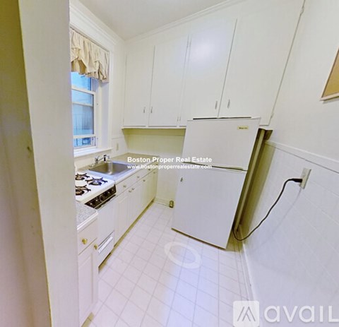 A kitchen with white appliances and cabinets is for sale.