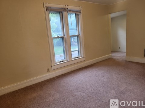 A room with a bed, a ceiling fan, and a guitar.