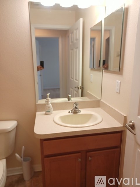 A bathroom with a sink, mirror, and toilet.