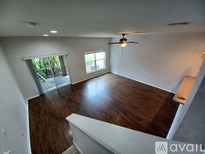 A room with a ceiling fan and a window with blinds.