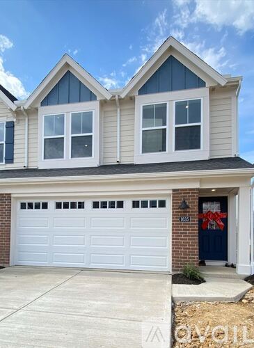 A two-story house with a white garage door and a blue door.