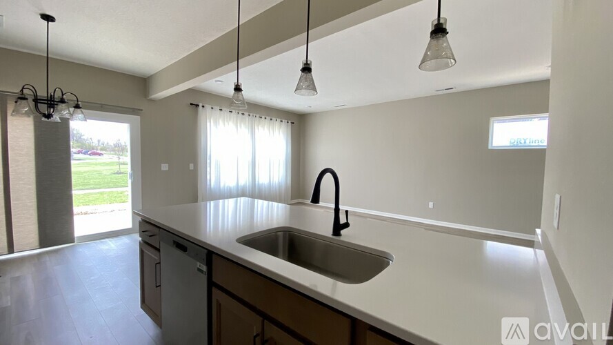 A kitchen with a sink and a window with curtains.