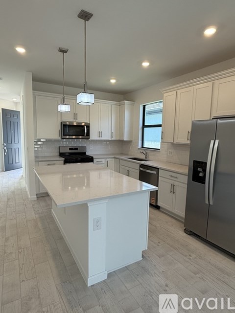 A kitchen with a large island and stainless steel appliances.