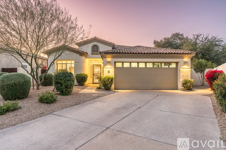A house with a driveway and landscaping in front of it.