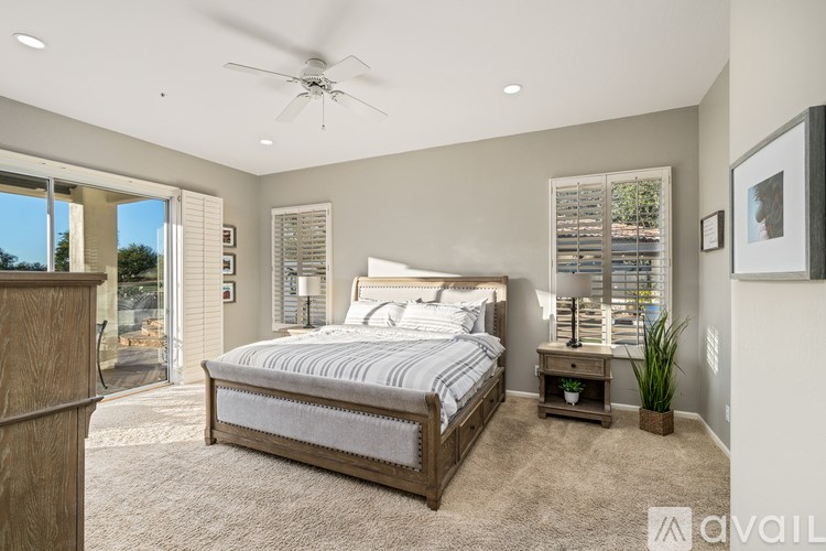 A bedroom with a large bed and a ceiling fan.