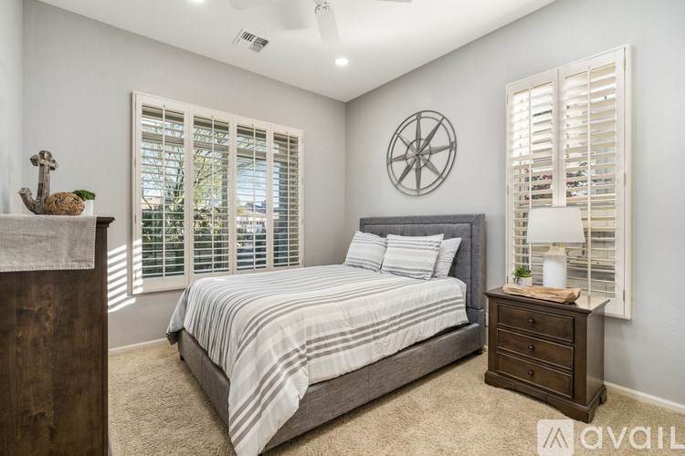 A bedroom with a bed, nightstand, and a wall clock.