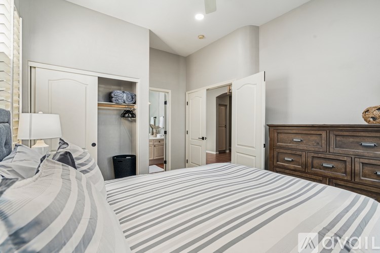 A bedroom with a large bed and a dresser.