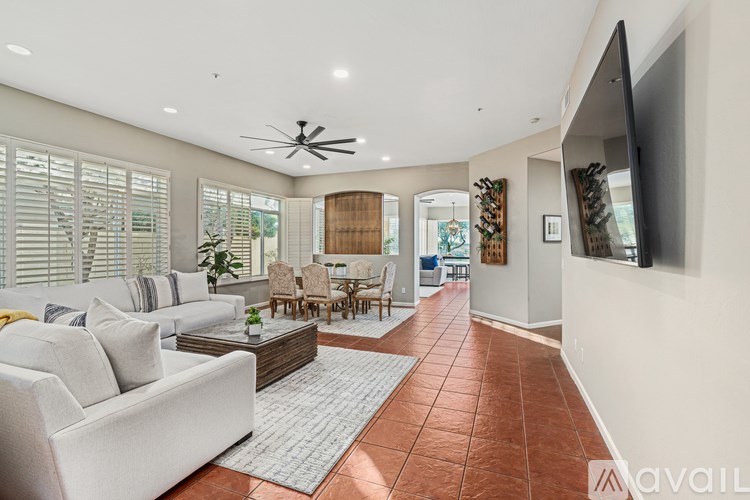 A living room with a white couch and a ceiling fan.