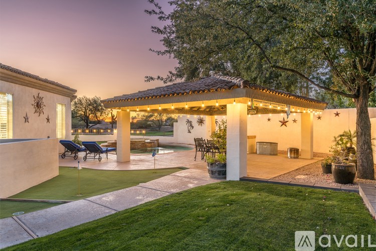 A house with a patio and a tree in front of it.
