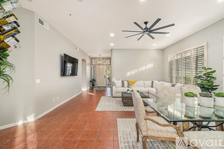 A modern living room with a glass dining table and chairs.