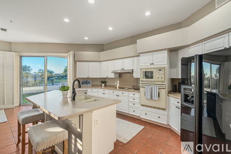 A kitchen with a large island and a refrigerator.