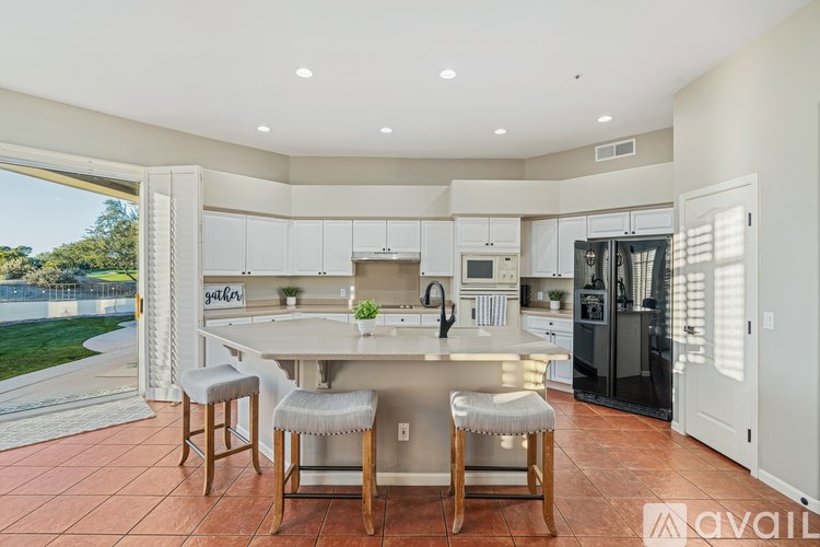 A kitchen with a large island and bar stools.