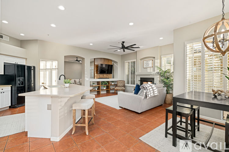 A spacious kitchen with a bar area and a dining table with chairs.