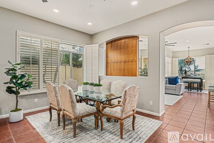 A dining room with a glass table and chairs.