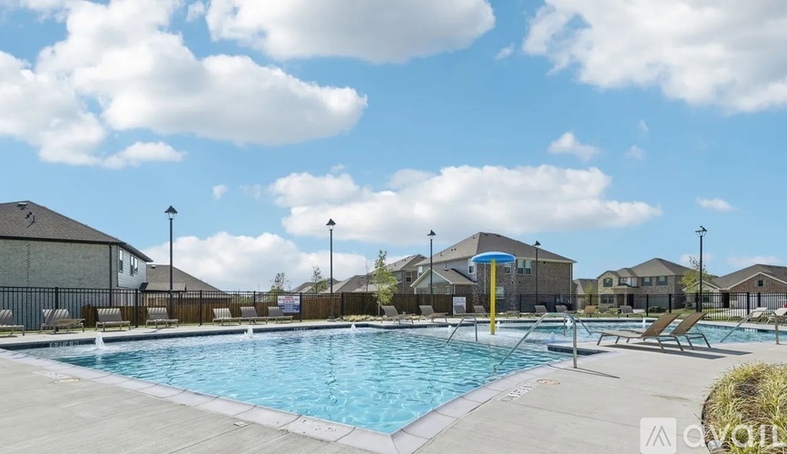 A large outdoor swimming pool with a slide and a sunshade.