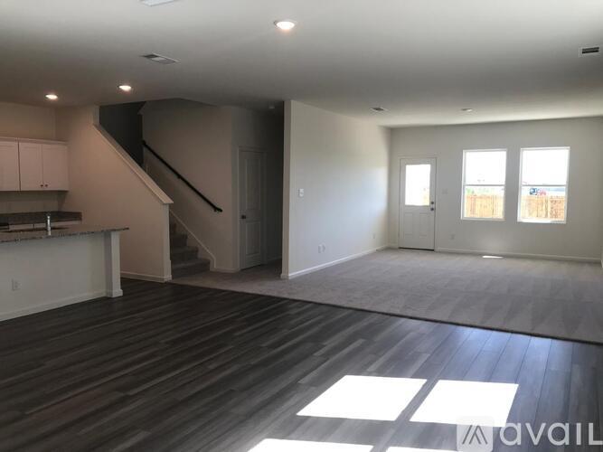 A spacious living room with hardwood floors and a staircase leading to the upper level.