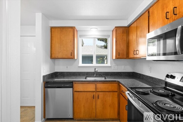 A kitchen with wooden cabinets and a black stove top.