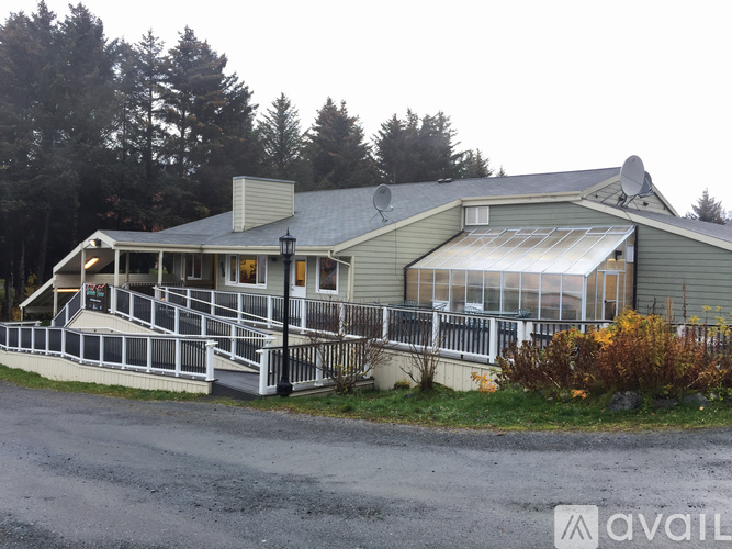 A house with a grey roof and a white fence.