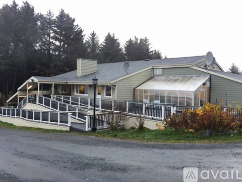 A house with a grey roof and a white fence.