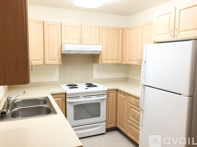 A kitchen with a white refrigerator, stove, and oven.
