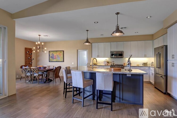 A kitchen with a dining table and chairs.