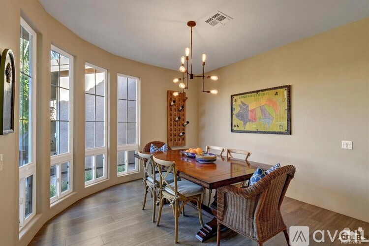 A dining room with a wooden table and chairs.