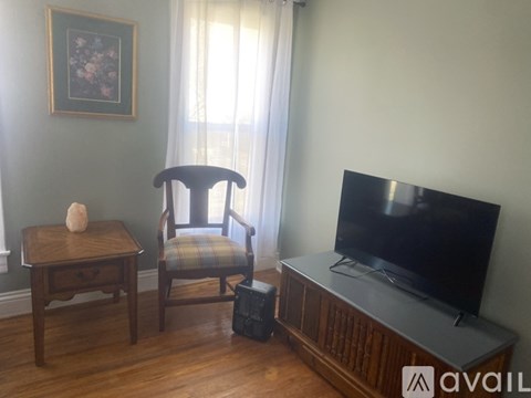 A chair sits in front of a television in a living room.