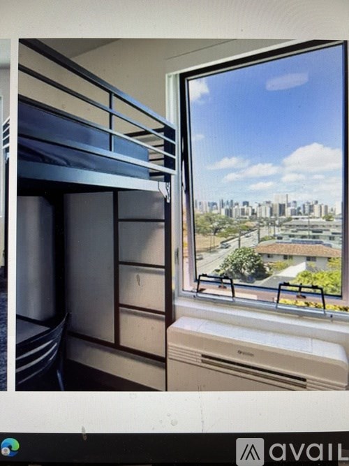 A window with a view of a cityscape and greenery outside.