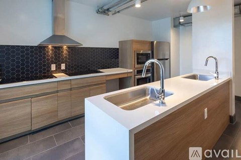 A modern kitchen with a white countertop and wooden cabinets.