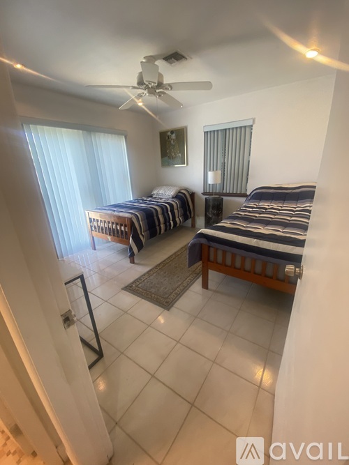A room with a bed, a sofa, and a ceiling fan.