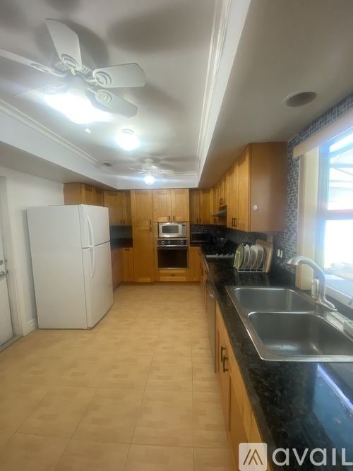 A kitchen with wooden cabinets and a white refrigerator.