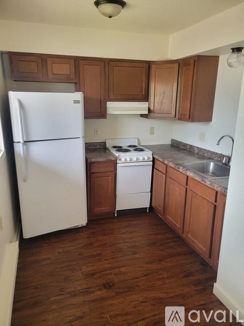 A kitchen with wooden cabinets and a white refrigerator.